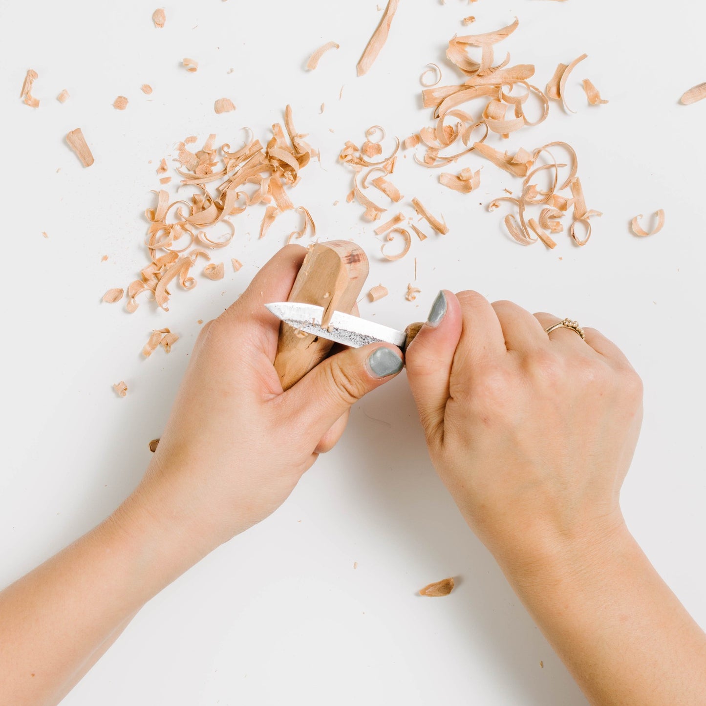 Person carving handle with a mikikichan carving knife.