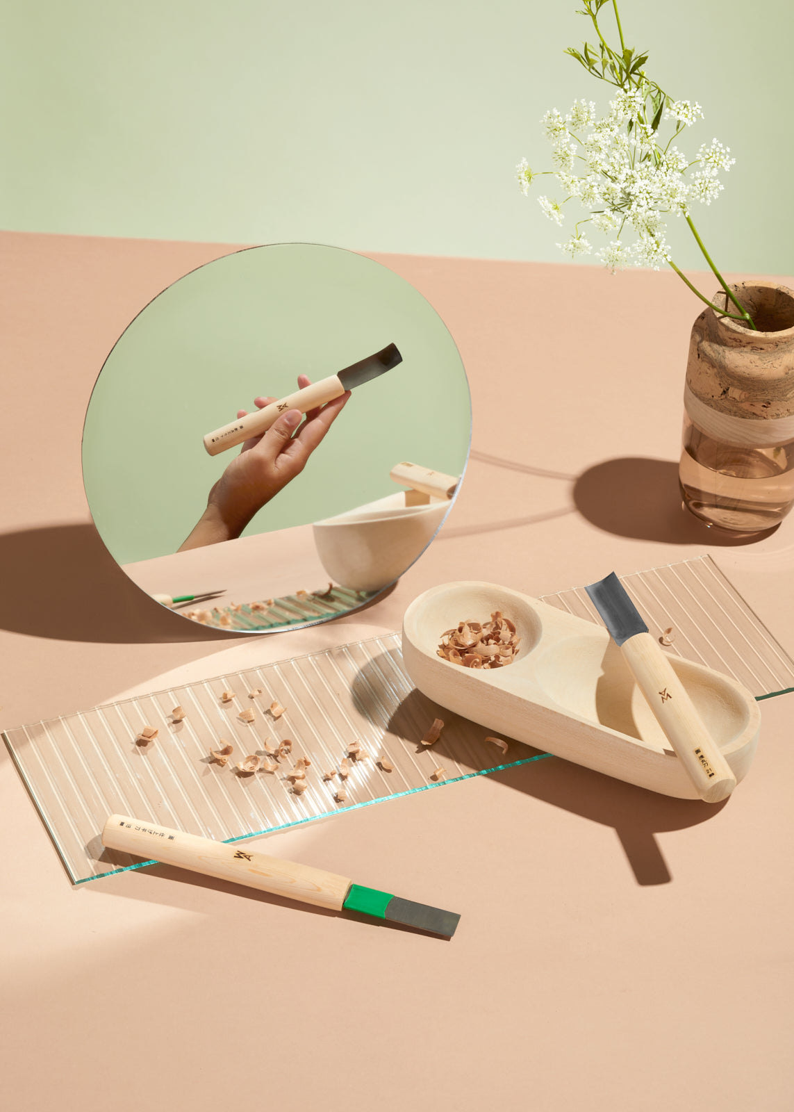 The three bowl tools are laid out creatively on a light pink table. The Ruth Marais Vase placed in the back with a flower in it. By Melanie Abrantes Designs