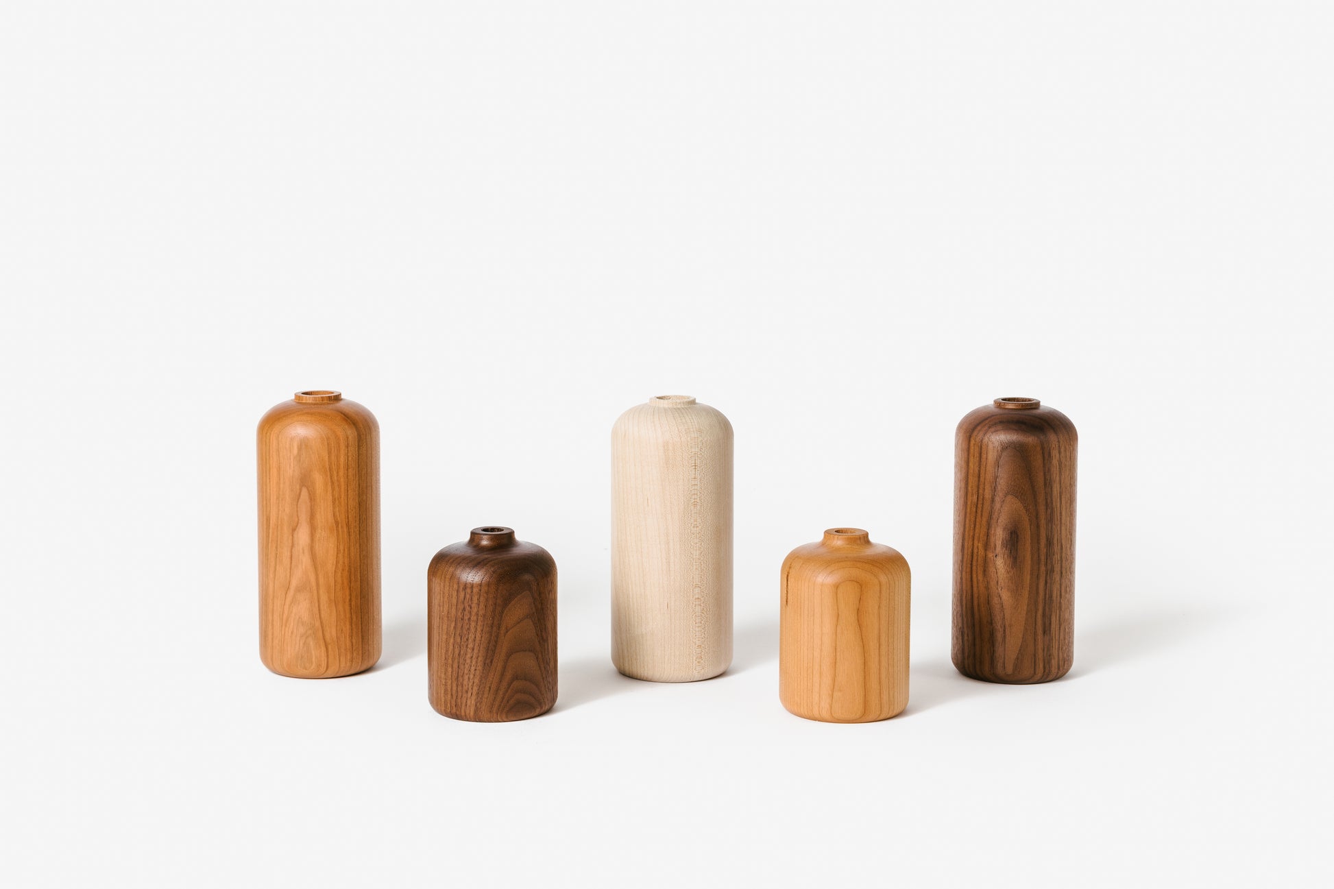 Collection of wood bud vases in various style and materials. By Melanie Abrantes Designs.