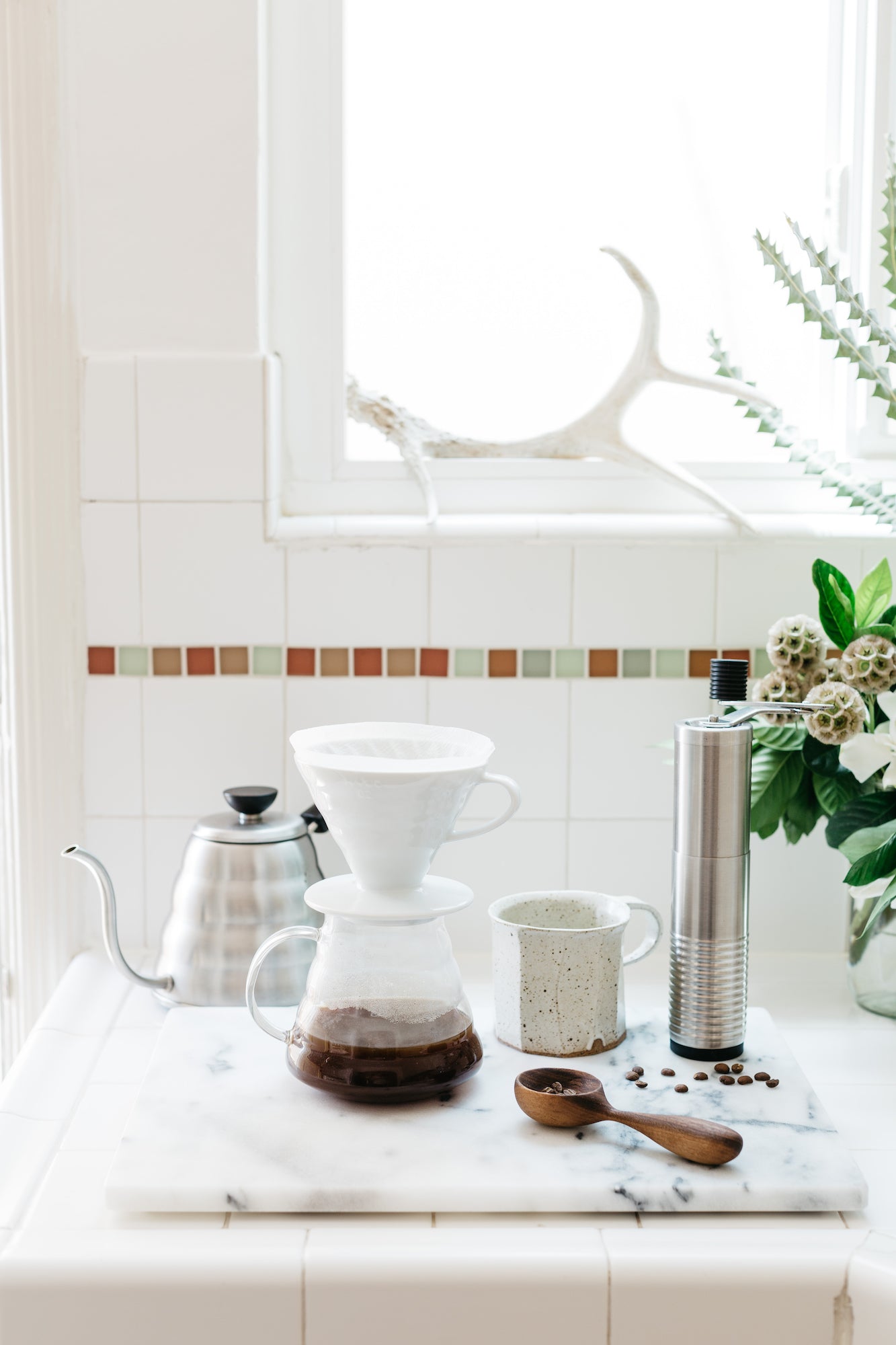 Walnut coffee spoon on counter with coffee beans. By Melanie Abrantes Designs.