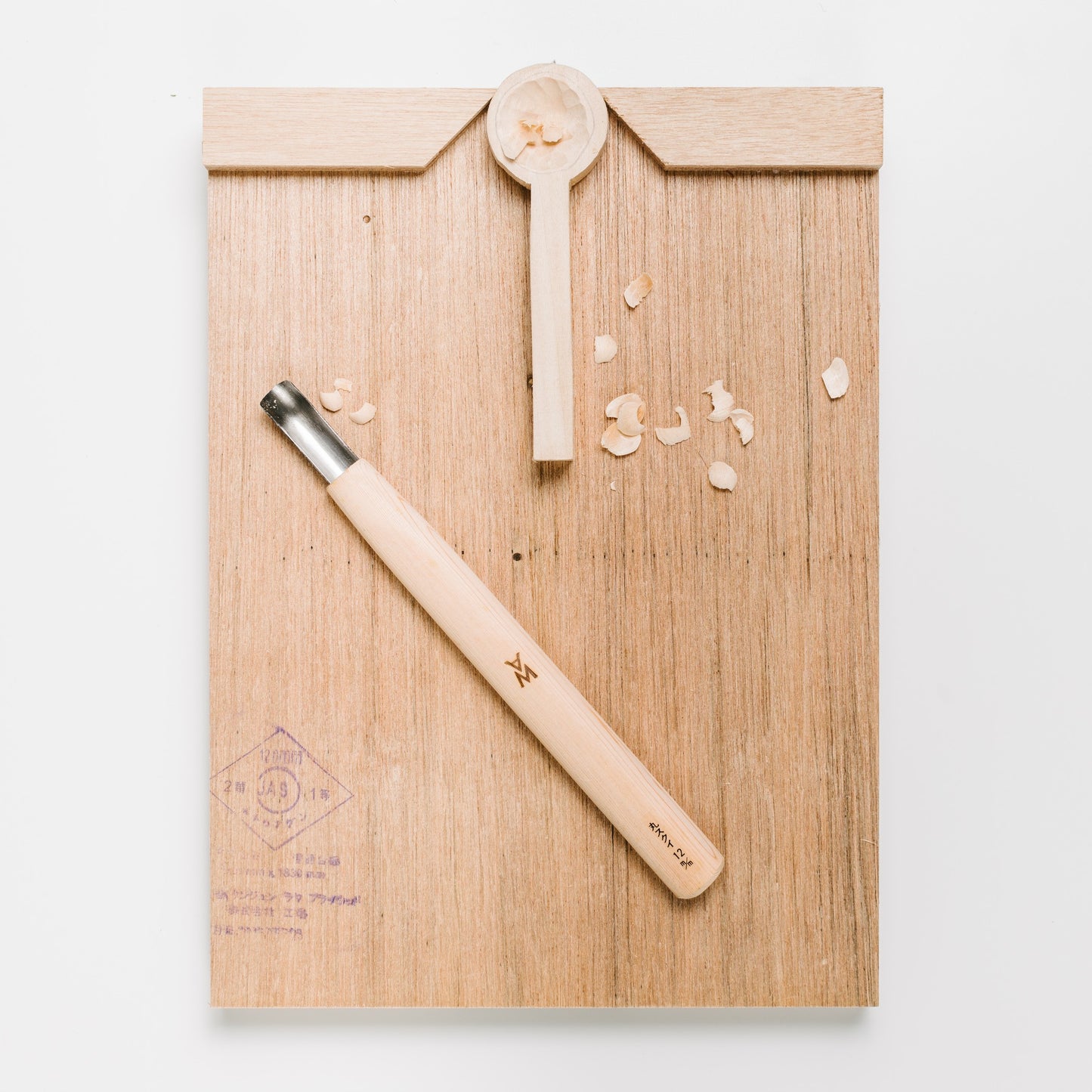 Bench Hook showing carving project wedged in place with a Japanese carving tool.