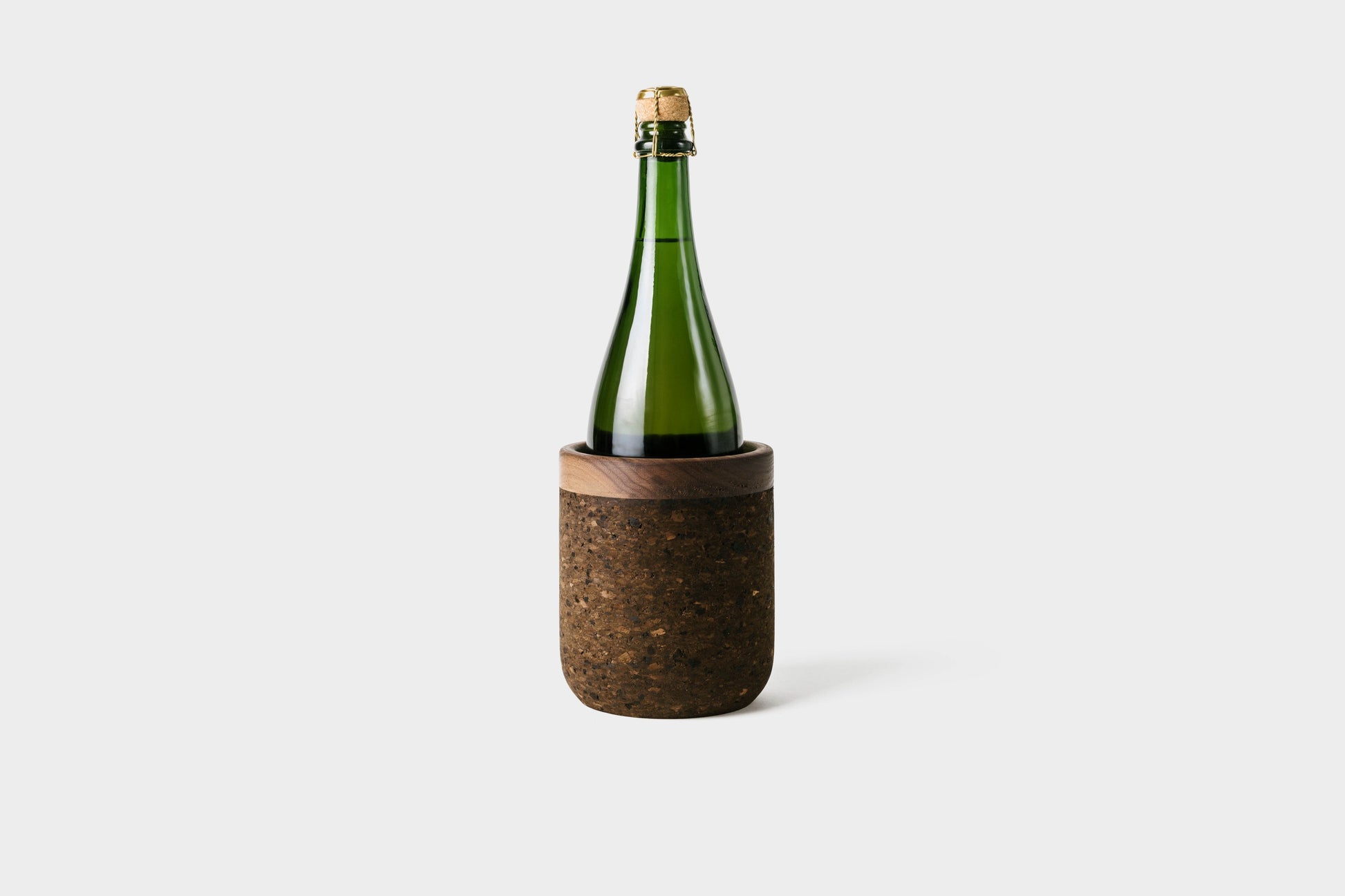 Cork wine cooler in charcoal cork with walnut trim. With champagne bottle inside. By Melanie Abrantes Designs.
