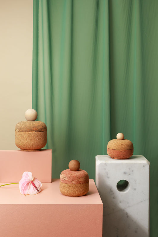 Cork bolo canisters by Melanie Abrantes Designs. Displayed on a pink and green set with marble accents.