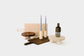 Collection of products from left to right: Walnut Mini Mesa Tray, Maple Big Bread Board, Heron Taper Candles, Maple Candle Holders, Walnut Big Bread Board, Mae Marais Vase, Maple Mini Mesa Tray