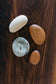 Collection of finished river stones. Top to bottom: Bass, Cherry, Buckeye, Cherry | Melanie Abrantes Designs