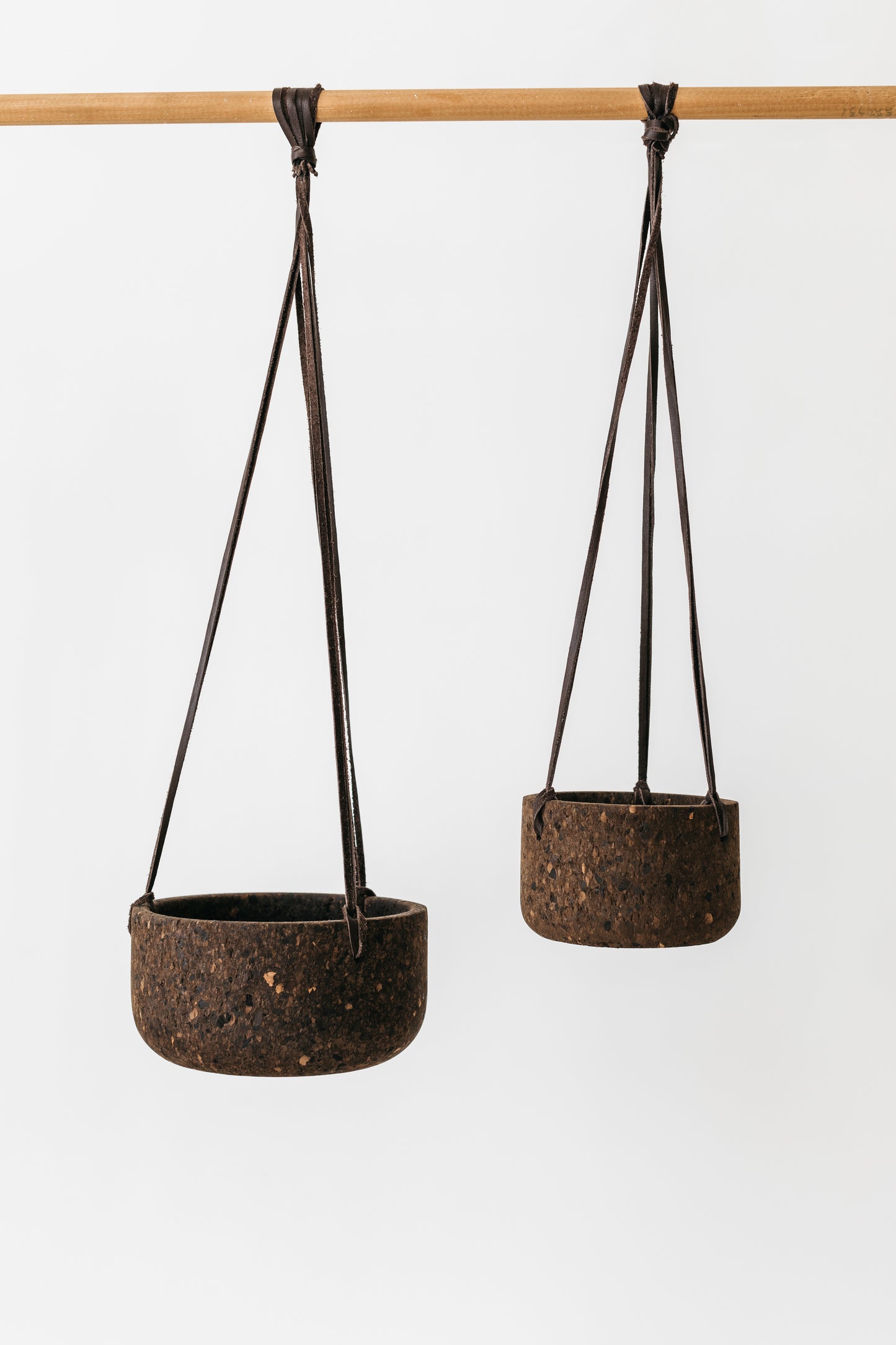 Large and small hand-turned charcoal cork planters shown hung.