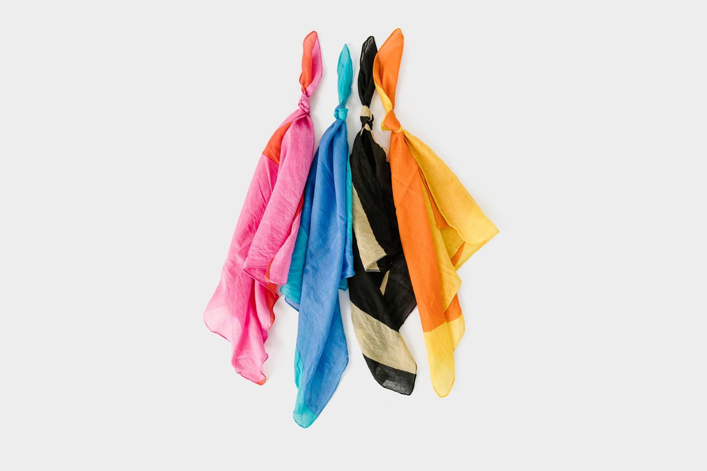 All four colors shown tied in a knot. From left to right is pink/red, periwinkle/aqua, black/beige, and orange/yellow. 