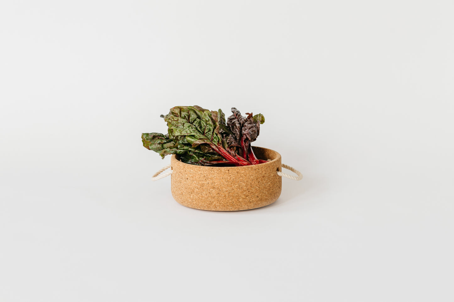 Large cork bowl filled with greens.