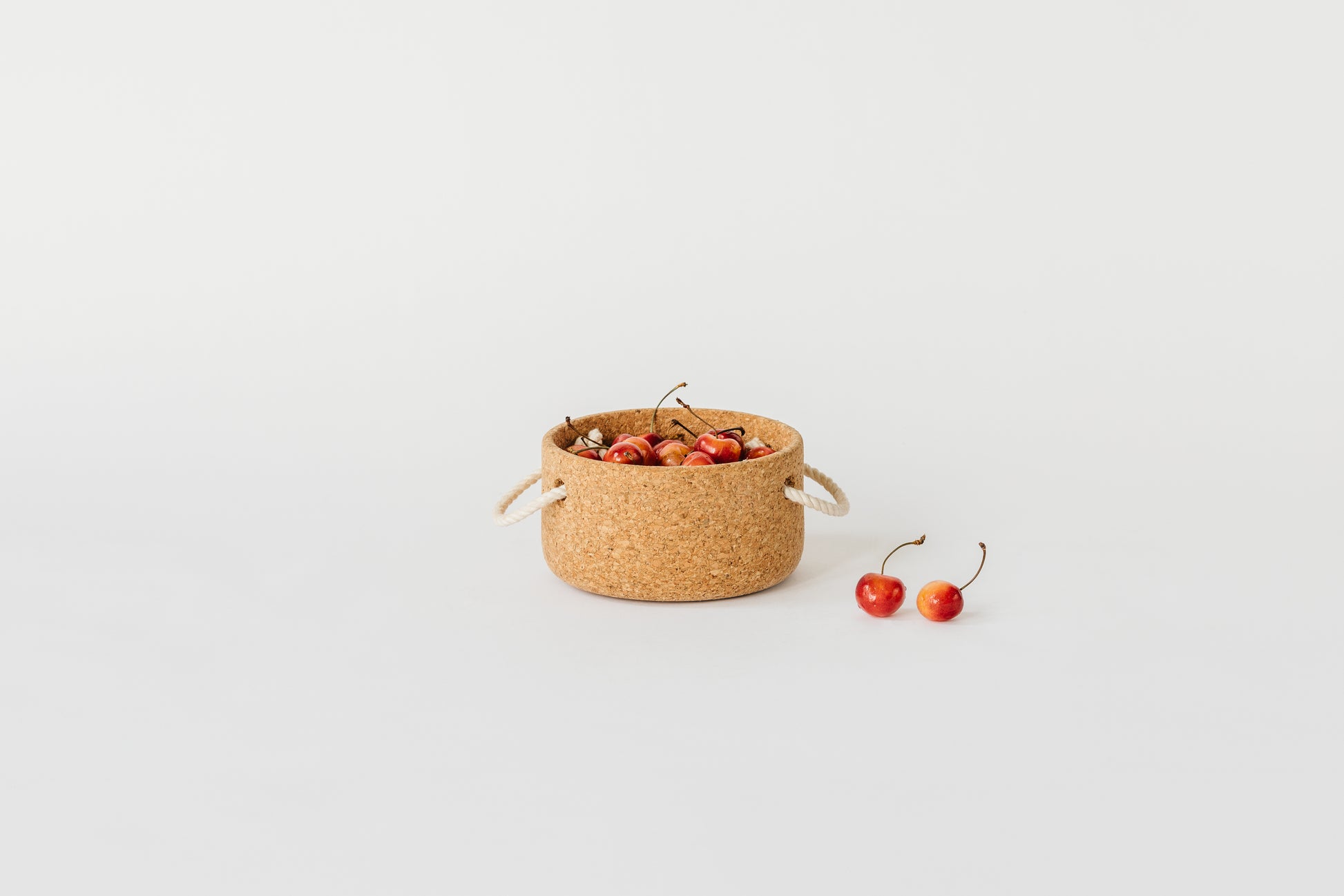 Small cork bowl with natural rope handles. Filled with cherries. By Melanie Abrantes Designs