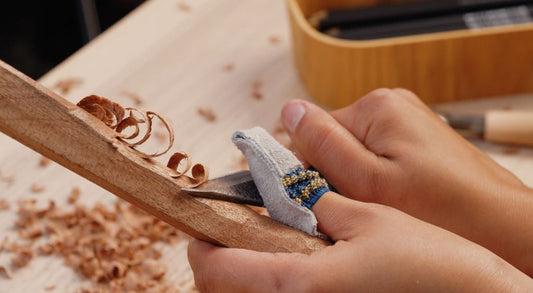 Carving cooking spoon with a right-handed knife. Using a thumb guard for extra cushion.