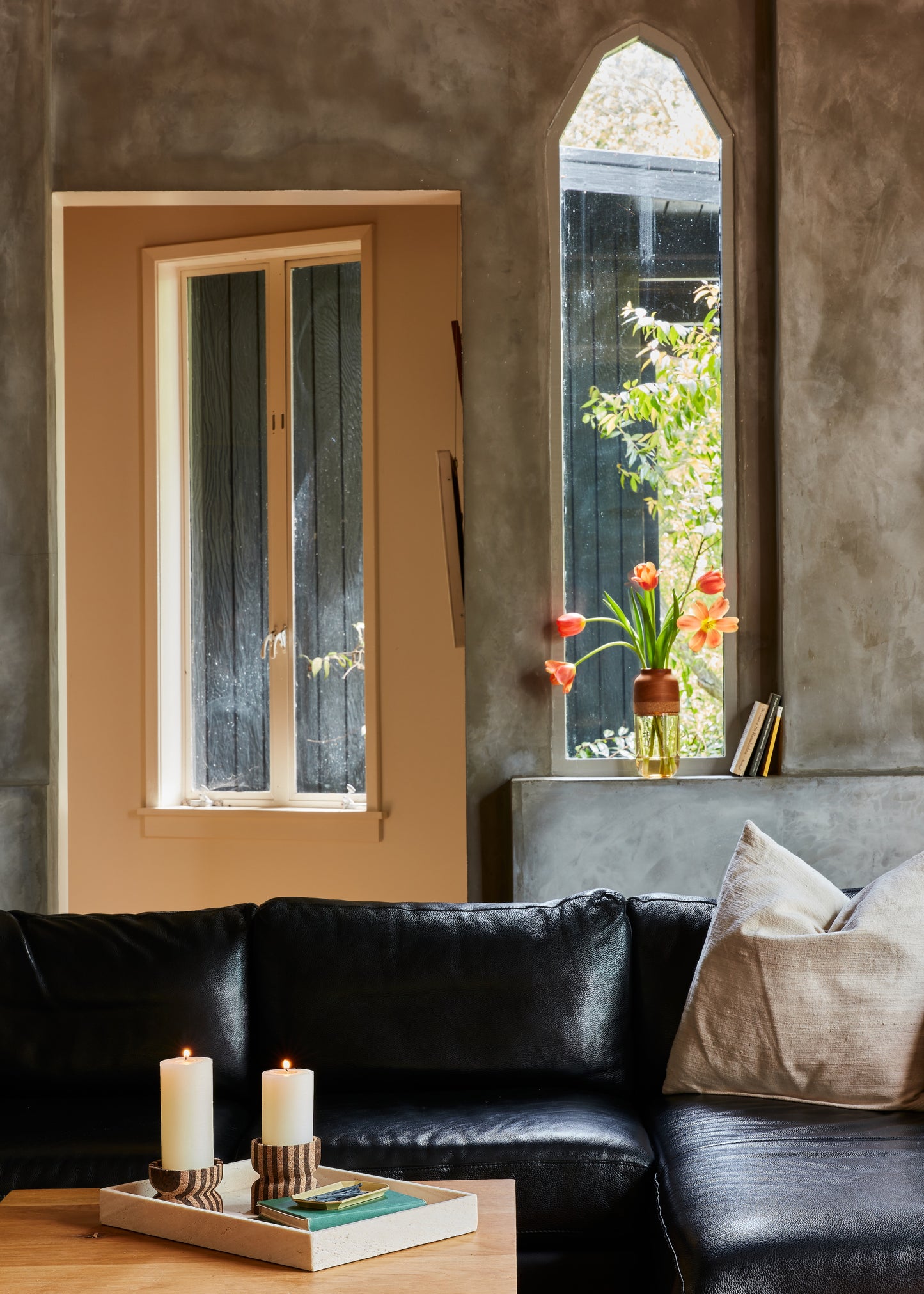 Striped cork candle holders shown as decor for a coffee table with a Marais Vase in the background on a window sill.