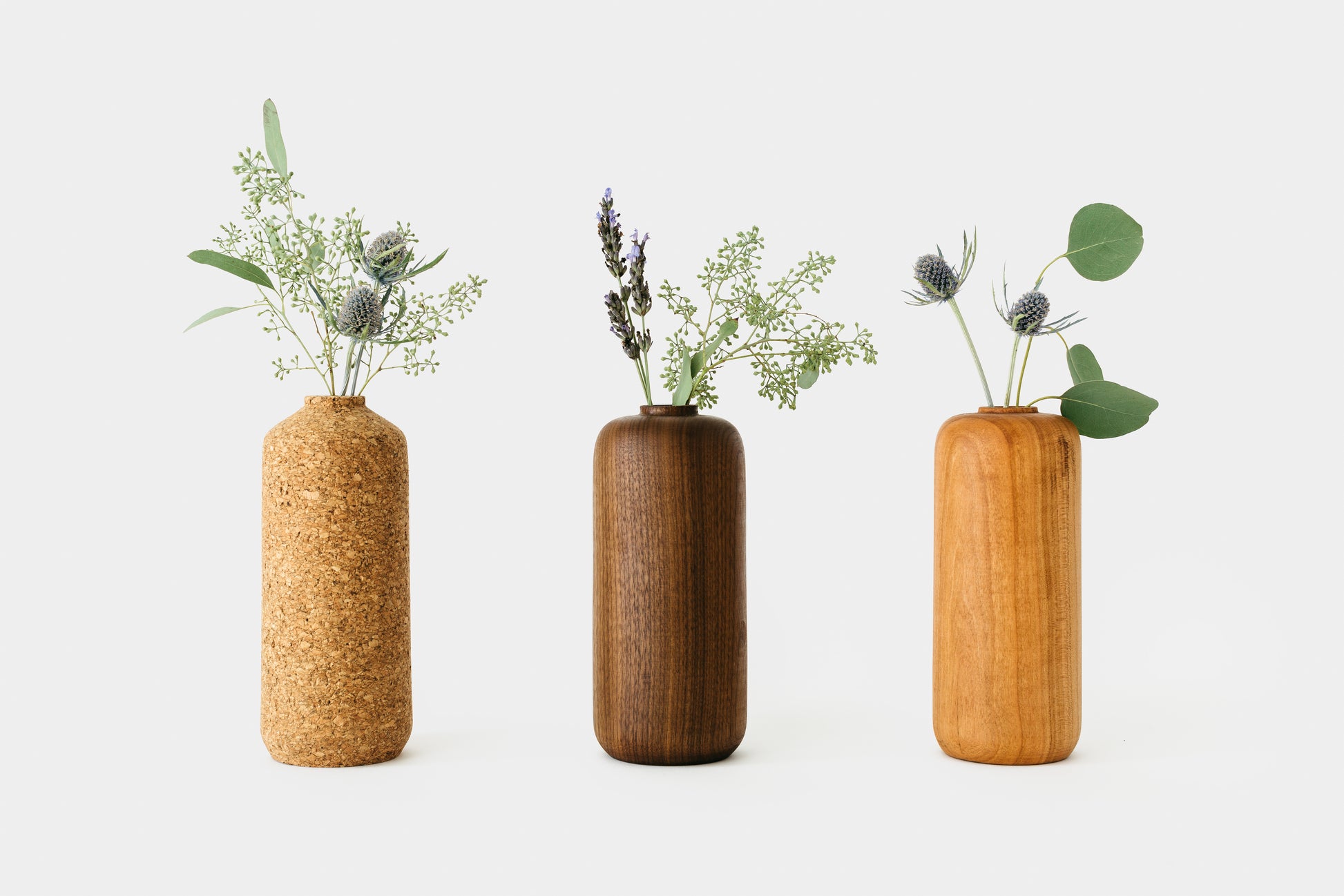 Collection of Tall Bud Vases holding flowers. Left to Right: Cork, Walnut, Cherry | Melanie Abrantes Designs