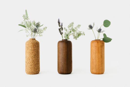 Various cork and wood vases holding plants. By Melanie Abrantes Designs.