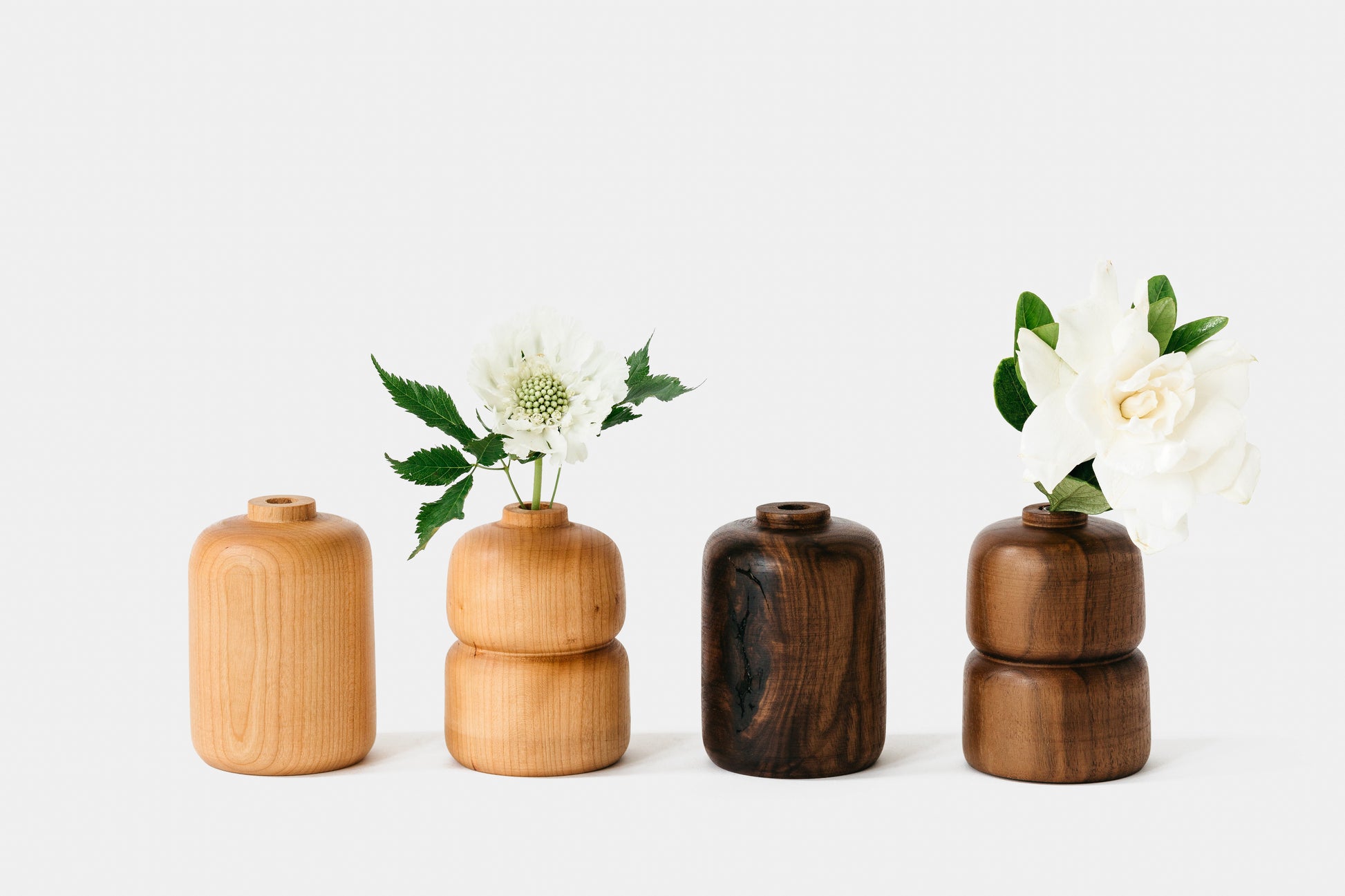 Collection of cherry and walnut bud vases with flowers. By Melanie Abrantes Designs