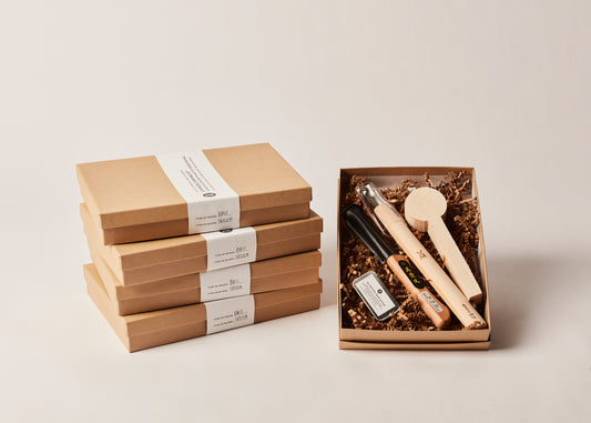 5 Orignal Spoon Carving Kits!!! By Melanie Abrantes Designs. Four stacked, closed boxes and one opened displaying wood butter, carving knife, spoon gouge, and spoon blank. 